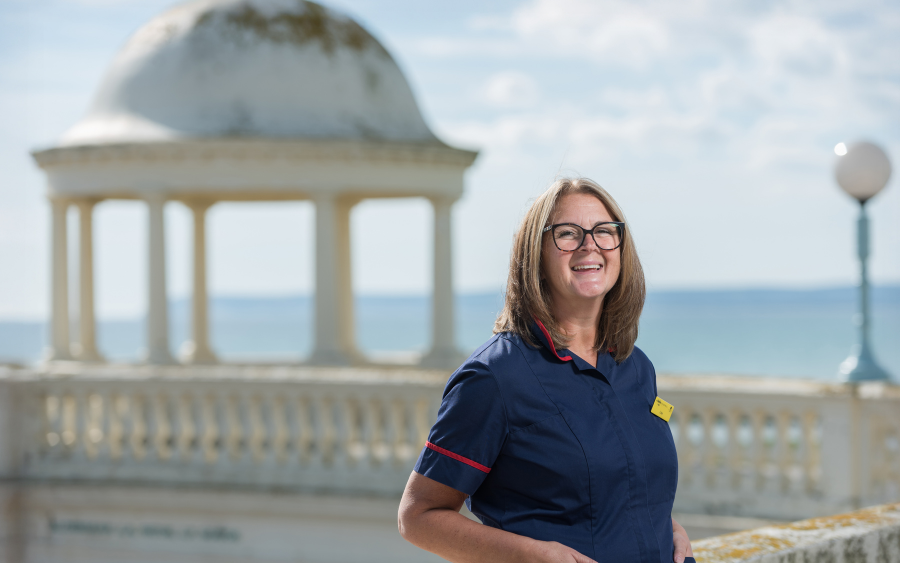 A photo of a Clinical Nurse Specialist standing outside one of the turrets near the De La Warr Pavilion in Bexhill.